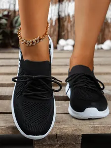 Detailopname van stijlvolle zwarte mesh sneakers voor dames met een elastische ronde neus.