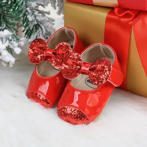 Red Christmas baby shoes with glitter bows and patent leather finish.