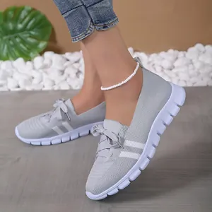 Detailed side view of lightweight grey flyknit walking shoes featuring flexible white soles