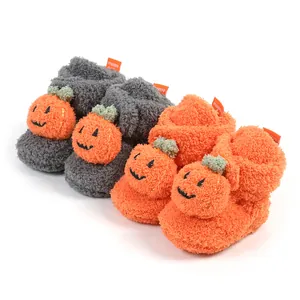 Dettaglio macro di graziosi stivali invernali in peluche con zucca arancione.