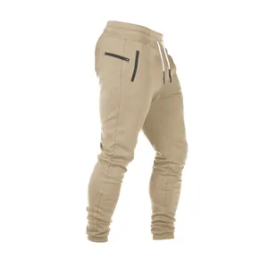 Detalle de pantalones jogger caqui para hombre con bolsillos de cremallera y cordones.