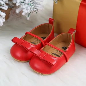 Detail shot of red Christmas baby princess shoes with bows and soft soles on white rug