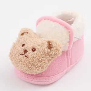 Close-up view of pink baby winter booties featuring a cute plush bear and warm lining