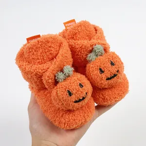 Dettaglio delle pantofole invernali in pile arancione con design a zucca per neonati