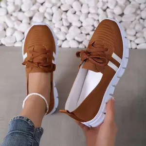 Detailed view of breathable brown knit walking shoes with flexible white thick soles