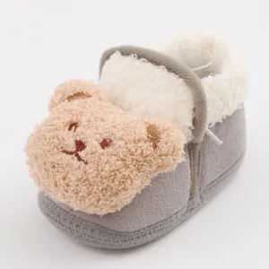 Detailed view of plush bear decoration on warm soft-soled baby booties for newborns