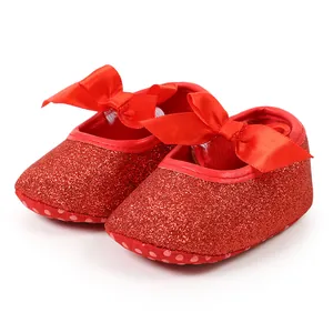 Detailed view of red glitter baby princess shoes with ribbon bow and soft sole