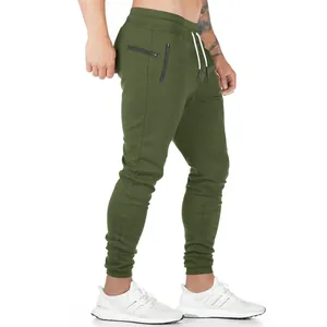 Detalle de perfil lateral de joggers verde oliva para hombre con bolsillos de cremallera.