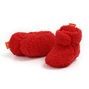 Vista dettagliata delle scarpine neonato rosse in peluche morbido