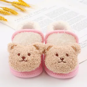 Close-up of pink cute cartoon teddy bear baby shoes with warm fleece material.