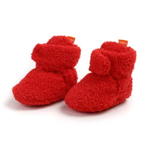 Dettaglio scarpine invernali in pile rosso per neonati con calda fodera morbida