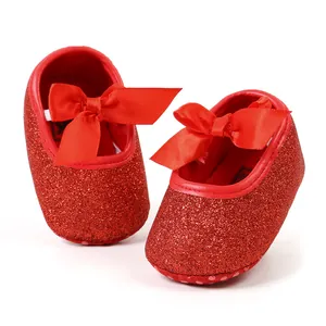 Detailed macro shot of red glitter baby princess shoes with satin ribbon bow for Christmas