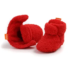Primo piano di calde scarpine invernali in peluche rosso con morbida fodera in pile