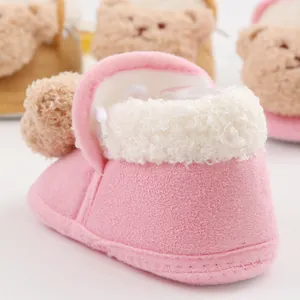 Close-up of pink plush baby winter bootie with cute cartoon bear decoration