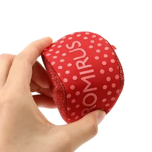 Close-up showing the flexibility of red soft-sole baby shoes with non-slip dots
