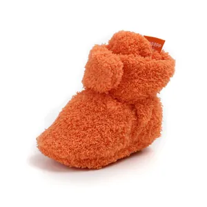 Dettaglio degli stivaletti invernali arancioni imbottiti per neonati con morbido pile