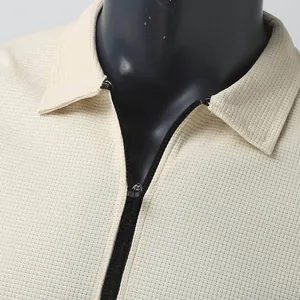 Gros plan sur la texture gaufrée et la fermeture éclair d'une veste beige pour homme à col.