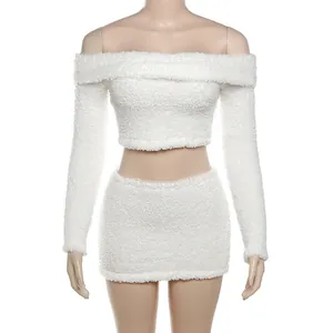 Λεπτομερής προβολή του λευκού χνουδωτού crop top και του ταιριαστού σετ μίνι φούστας