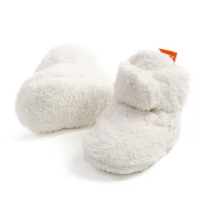 Dettaglio di scarpine da neonato in morbido peluche bianco spesso con fodera in pile