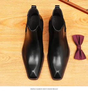 Vista superior de elegantes botas de negocios de cuero negro sobre fondo de madera