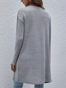 Detail view of grey long-sleeved knitted cardigan showing the back texture and fit.
