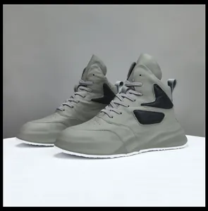 Profilo laterale di sneakers alte in pelle grigia con suole spesse e pannelli a strati