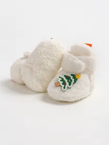 Primo piano di scarpine bianche in peluche per neonati con ricamo di Natale
