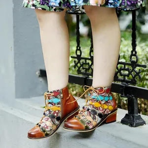Close-up detail of handmade retro patchwork leather ankle boots with colorful floral patterns