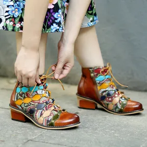 Detailed view of handmade genuine leather vintage patchwork ankle boots being tied