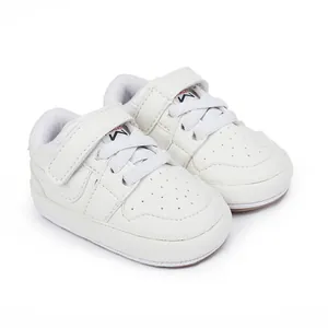 White soft-soled baby walking shoes with velcro straps and lace details