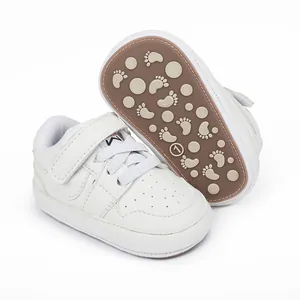 Close-up of white baby walking shoes with non-slip rubber soles and footprint pattern
