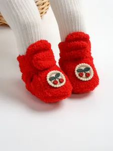 Dettaglio scarpine invernali neonato in morbido peluche rosso con ciliegie
