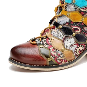 Close-up detail of handmade leather patchwork boots with retro patterns and rivets