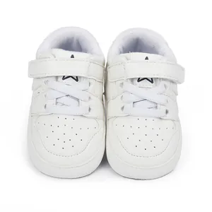 Detailed front view of white casual infant walking shoes featuring a blue star logo