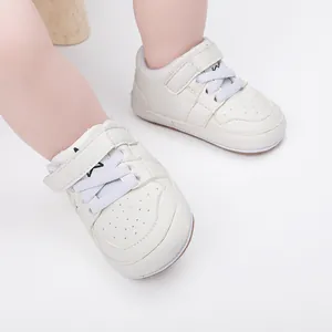 Close-up of white soft-soled baby walking shoes worn by an infant for indoor use