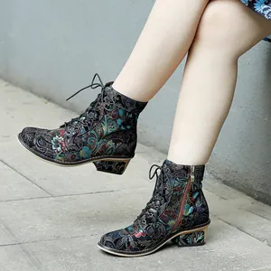 Detail view of retro floral print ankle boots with side zipper and lace-up design