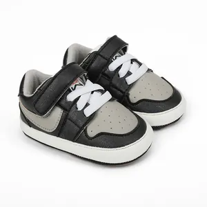 Close-up of black and grey baby walking shoes with soft soles and velcro straps.