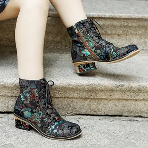 Detailed view of vintage floral print ankle boots with elegant embroidery on stone steps