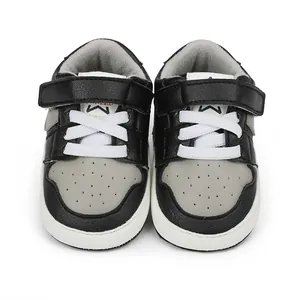 Close-up of black and grey baby walking shoes with white velcro strap and star logo
