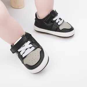 Detailed view of black and grey baby walking shoes with adjustable velcro straps