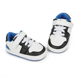 Macro detail of white, black and blue infant walking shoes with soft rubber soles.