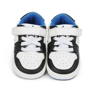 Front view of black and white toddler walking shoes with blue interior and rubber sole
