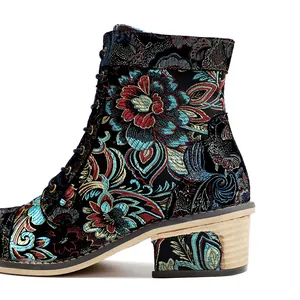 Close-up of vintage floral embroidered women's ankle boots with patterned block heel.