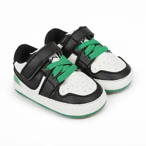 Detail of baby pre-walker shoes with black white green leather and velcro strap