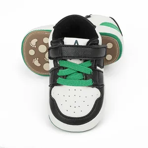 Close-up view of baby learning shoes with green laces and anti-slip rubber soles