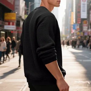 Detailed view of men's black jacquard waffle knit crewneck sweatshirt in street setting