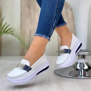 Detail shot of stylish white platform loafers featuring a navy blue strap and metal buckle