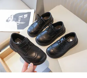 Detail van het klassieke Britse brogue-ontwerp op zwarte leren kinderschoenen.