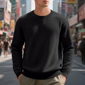 Macro detail showing the intricate waffle knit texture on a black men's crewneck sweatshirt.