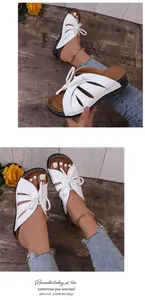 Detailed view of stylish white bow-knot hollow-out platform sandals worn by model.